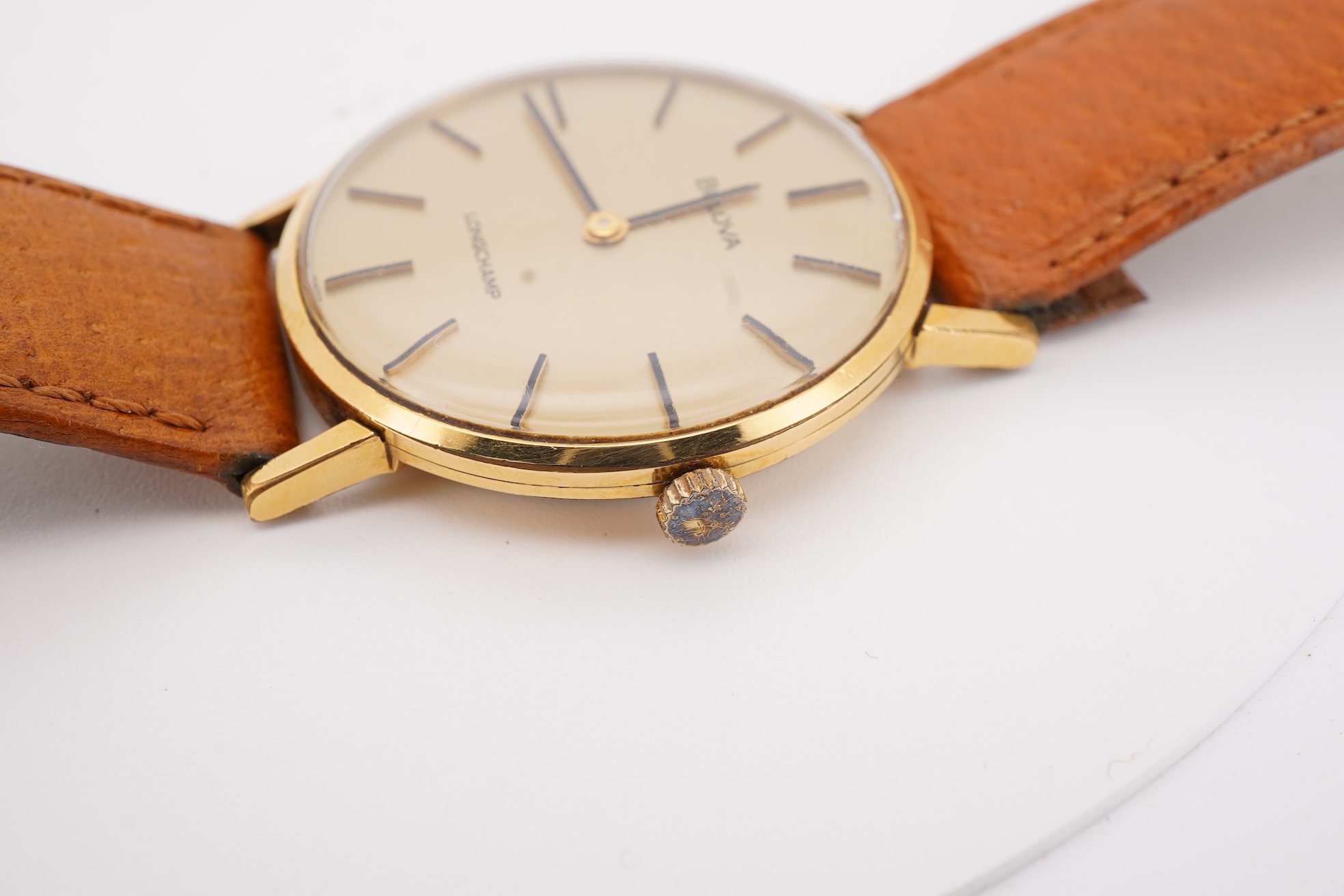 A gentleman's steel and gold plated Bulova Longchamp manual wind wrist watch, with baton numerals, case diameter 33mm, on a tanned leather strap.